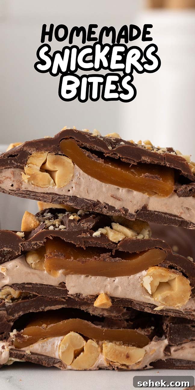 Three irresistible homemade Snickers bites with layers of rich chocolate, creamy caramel, fluffy nougat, and crunchy peanuts are decadently stacked on top of each other.