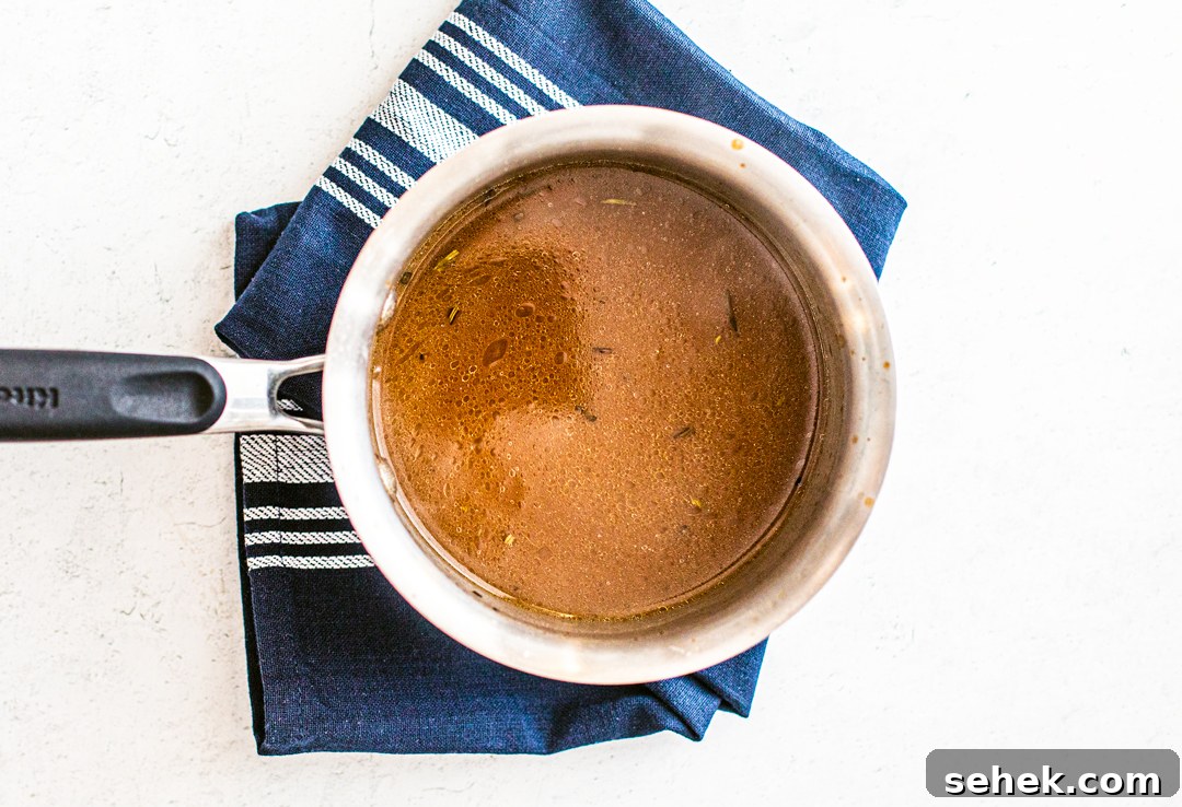 Brie and Roast Beef Sandwiches with Savory Au Jus 5 Overhead shot of saucepan with jus.