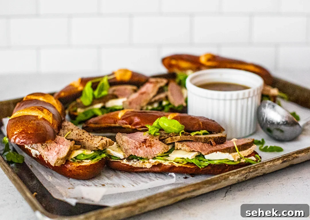 Brie and Roast Beef Sandwiches with Savory Au Jus 6 Side shot of brie and beef sandwiches with dipping dish of jus.
