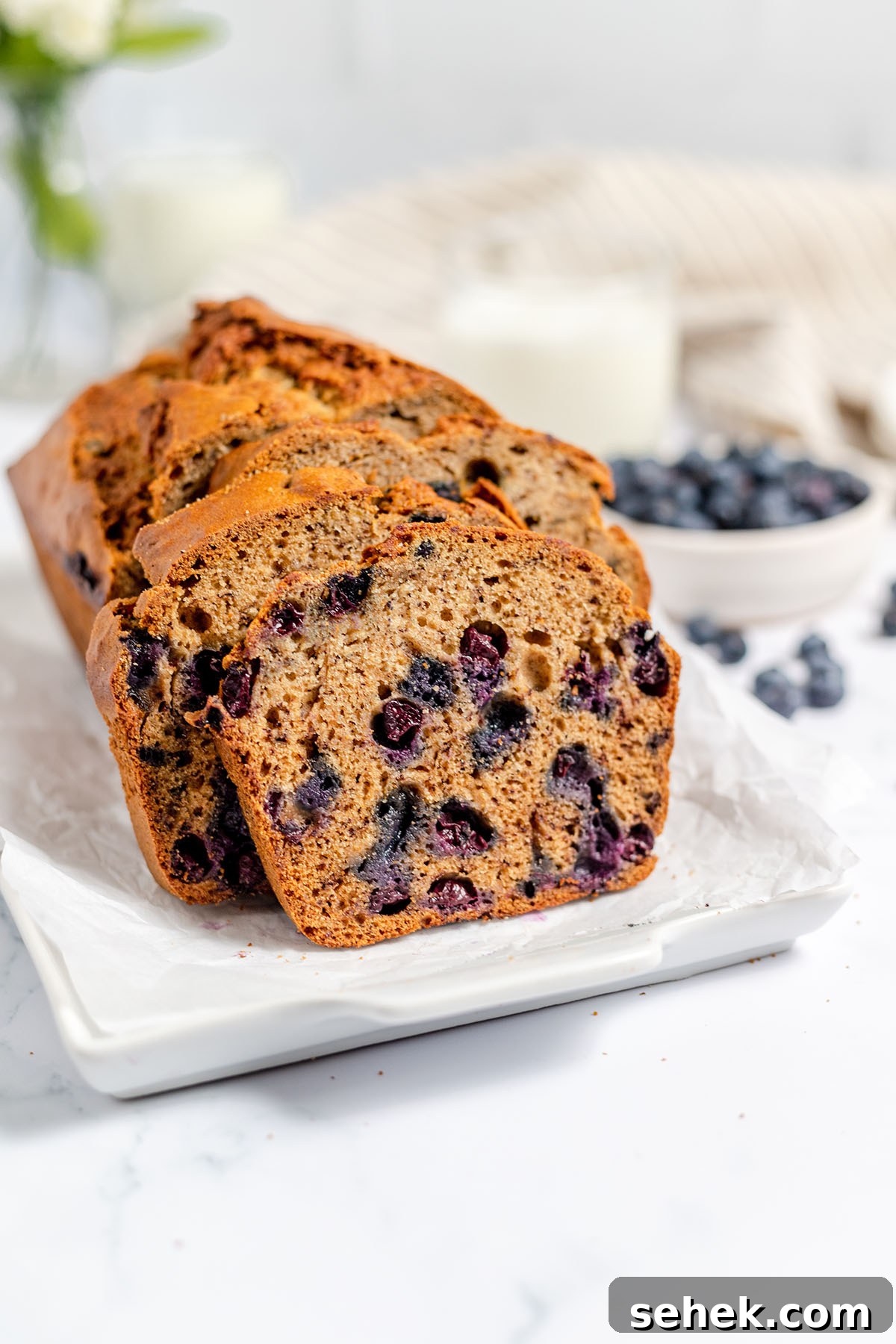 Moist Blueberry Banana Bread Recipe with Lemon Glaze 2 Blueberry Banana Bread on a white serving platter.
