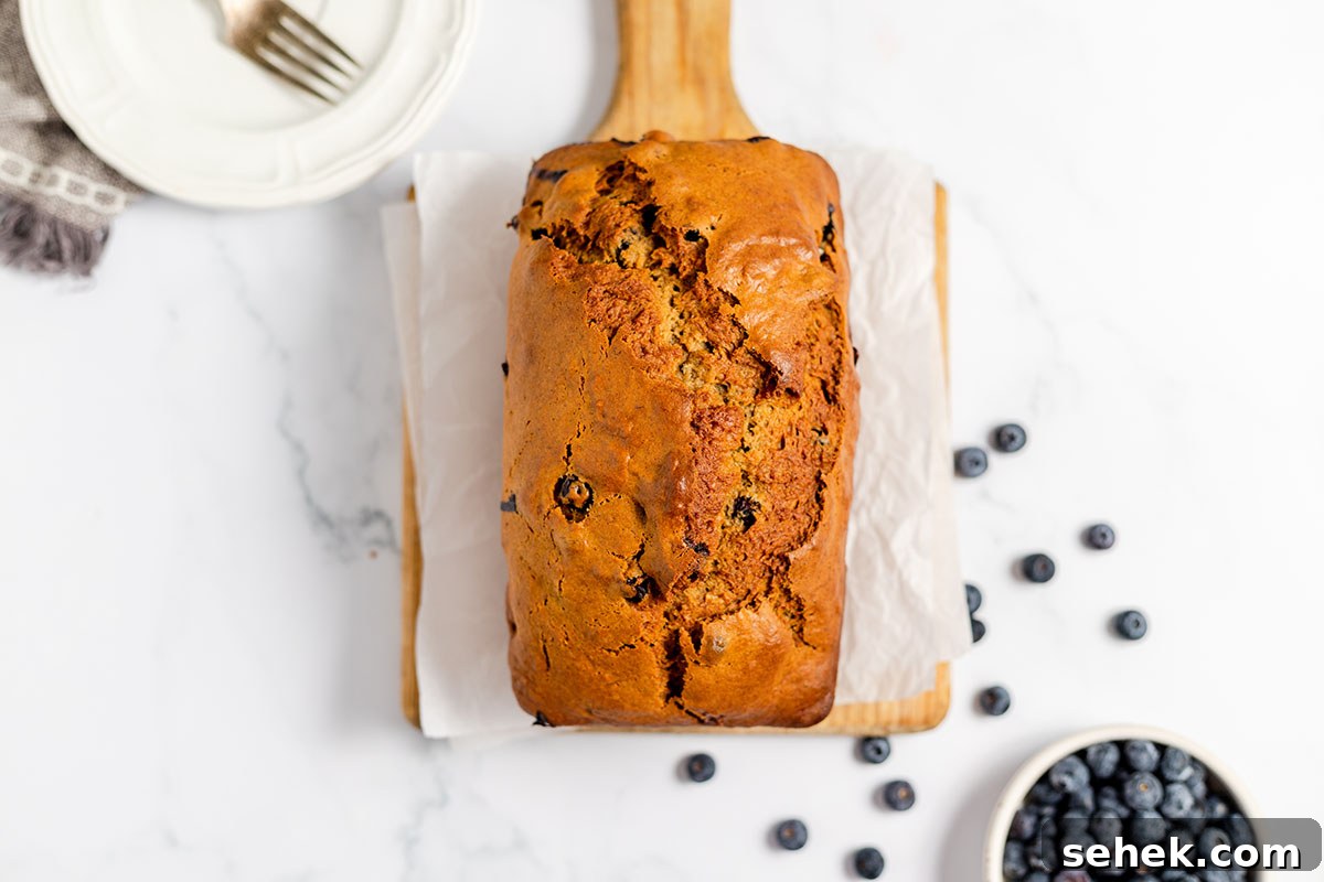 Moist Blueberry Banana Bread Recipe with Lemon Glaze 4 Blueberry Banana Bread loaf served on a wooden serving board.