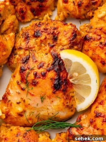 Seasoned and chicken thighs garnished wtih lemon wedges and fresh dill.