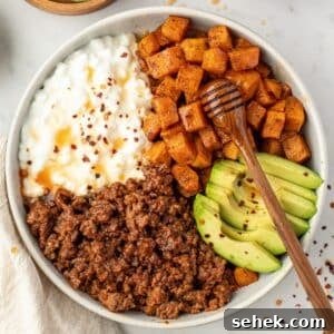 Spicy Honey Beef Bowls with Garlic Rice and Crispy Veggies 15 A bowl filled with sweet potatoes, cottage cheese, and ground beef.