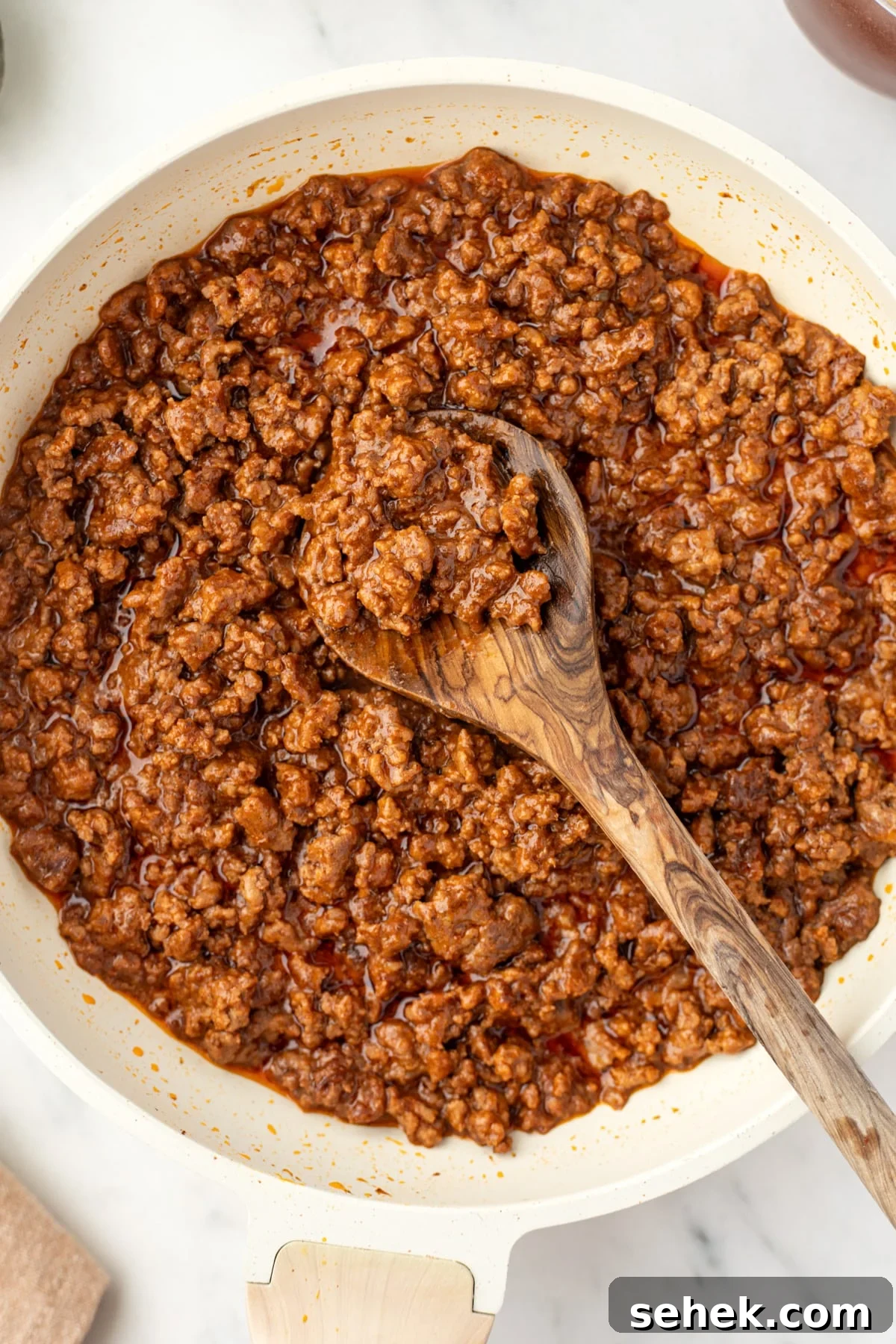 Spicy Honey Beef Bowls with Garlic Rice and Crispy Veggies 7 A skillet filled with saucy ground beef that has been cooked.