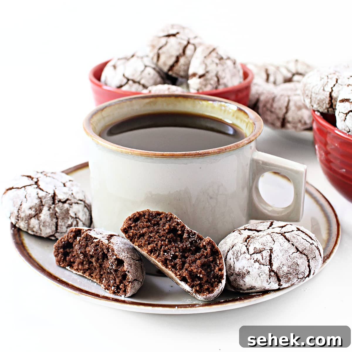 Chewy Almond Flour Chocolate Cookies with cocoa , shown broken in half with soft crumb inside, on a saucer with coffee.
