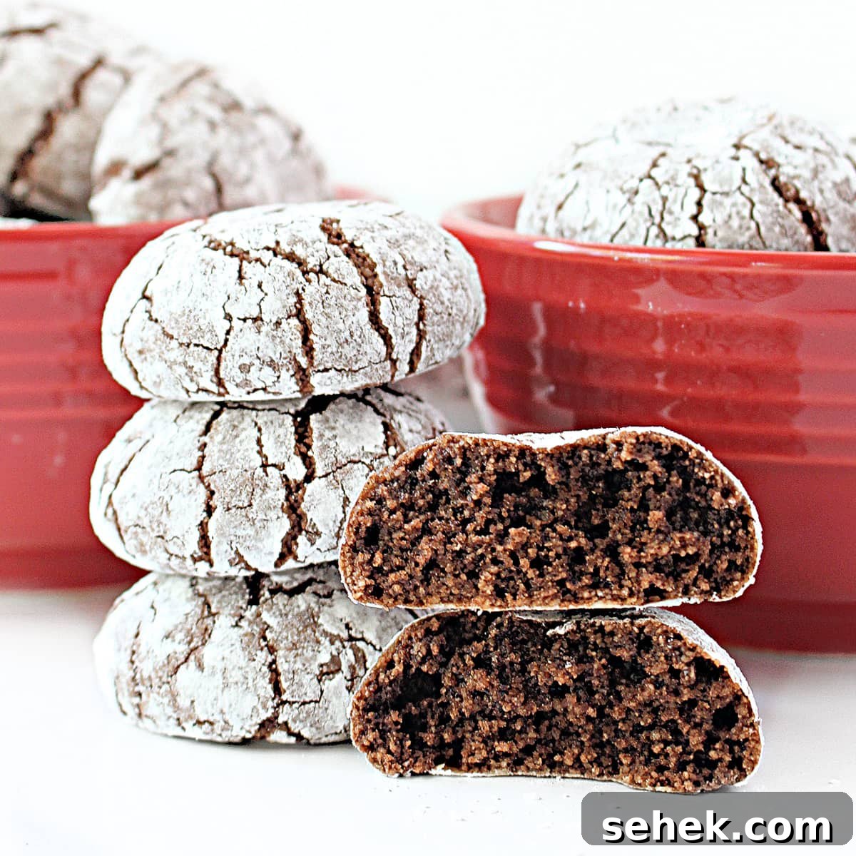 Stack of almond flour cookies with on thick cookie split in half showingchocolate crumb inside.