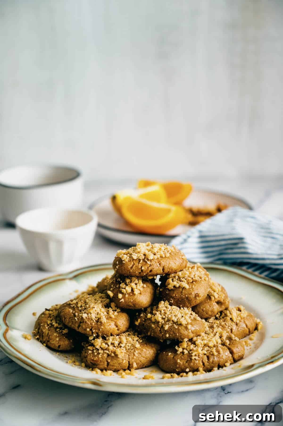 Melomakarona Greek Christmas Honey Cookies Recipe 2 a plate of melomakarona (Greek festive cookies) on a marble surface.