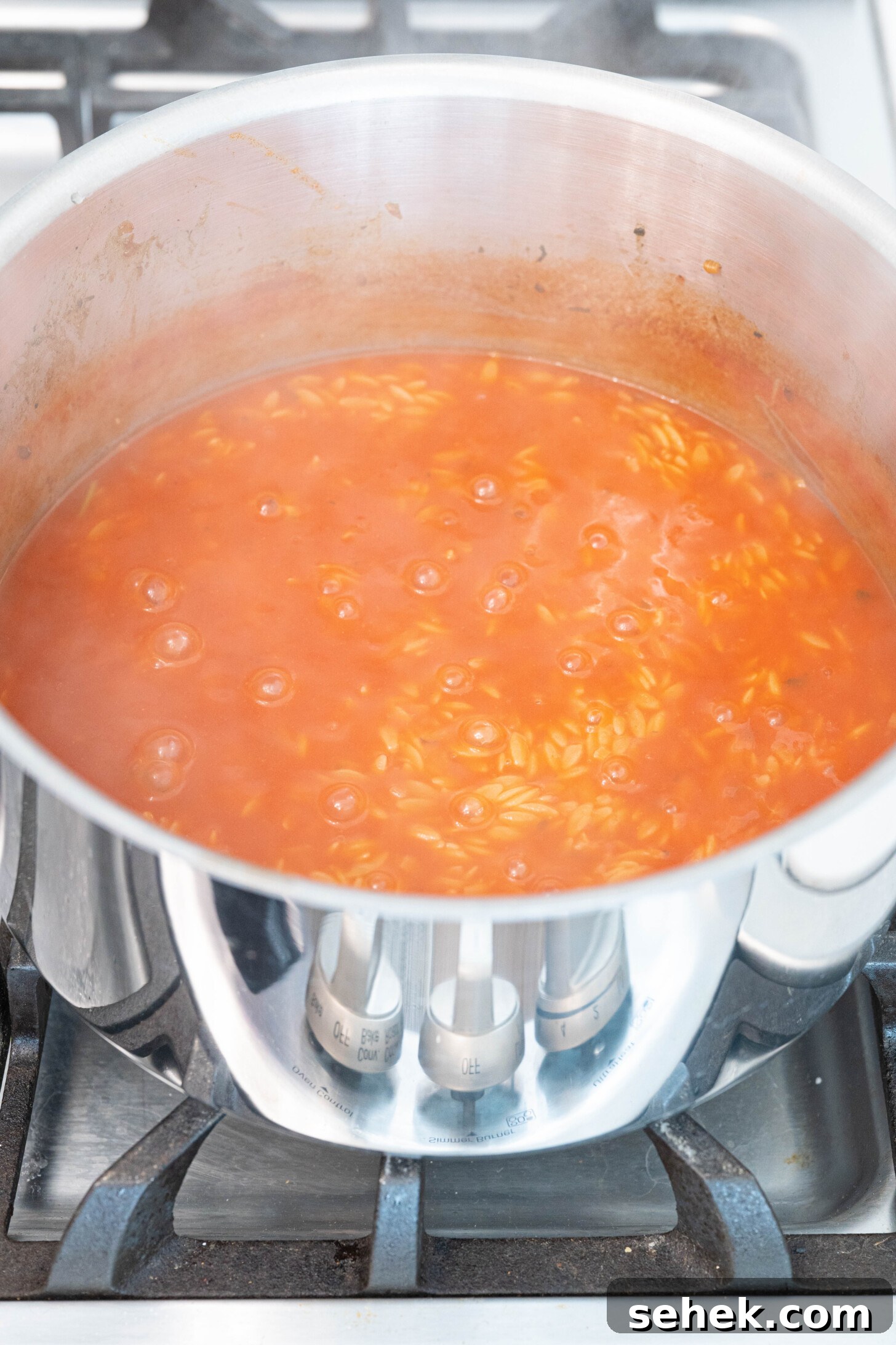 Moroccan Lamb and Orzo Recipe with Warm Spices 8 a pot of tomato sauce and orzo boiling
