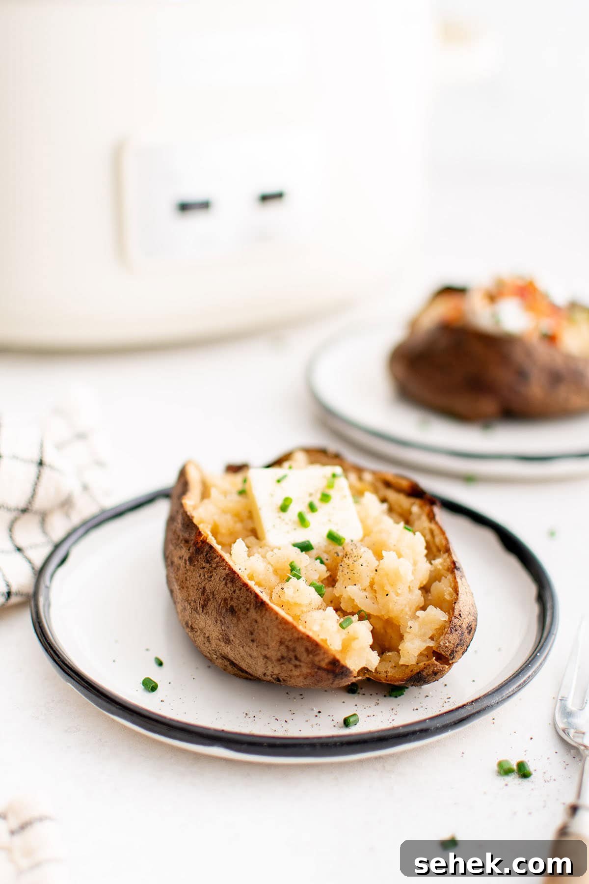photo of a baked potato with butter on a plate