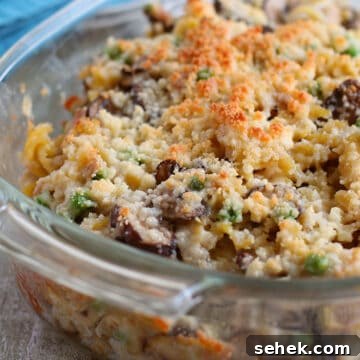 Creamy Tuna Noodle Casserole Without Soup 10 baked casserole in white dish with teal blue napkin in background