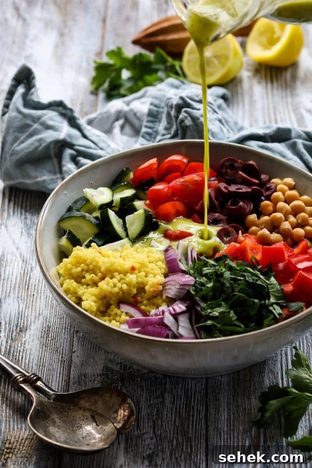 Vibrant Vegan Couscous Salad with Roasted Veggies and Herbs 3 Pouring dressing over pearl couscous salad.