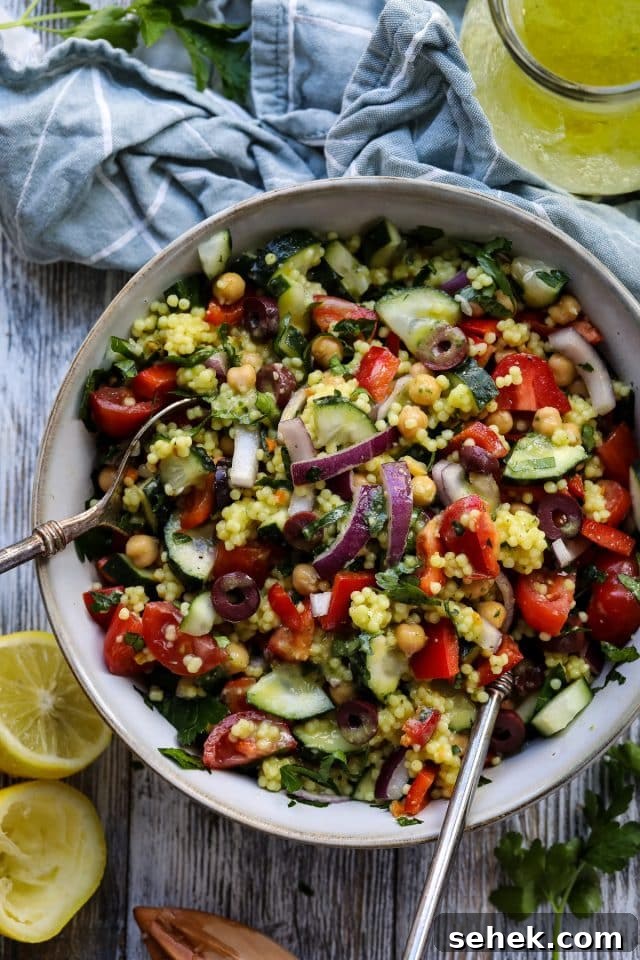 Vibrant Vegan Couscous Salad with Roasted Veggies and Herbs 8 Couscous salad in a bowl with utencils.