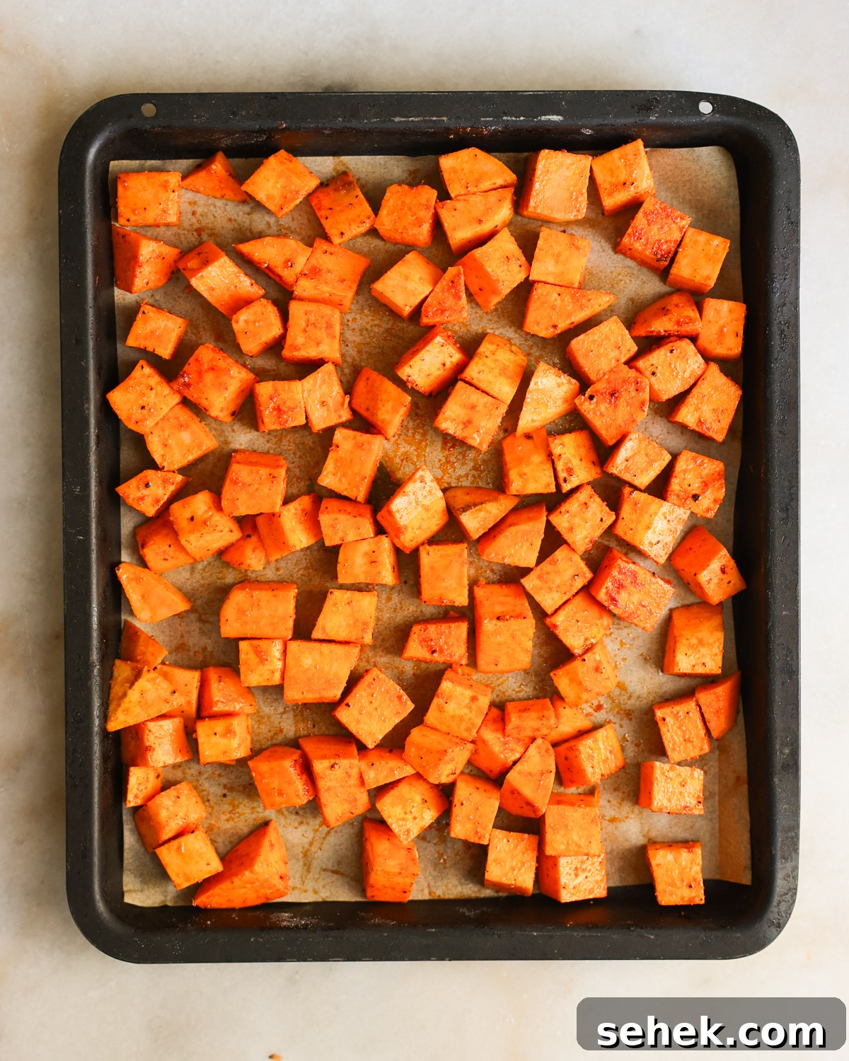 Perfectly Roasted Sweet Potatoes: Crispy Edges & Tender Centers 8 Sweet potatoes spread on baking sheet.