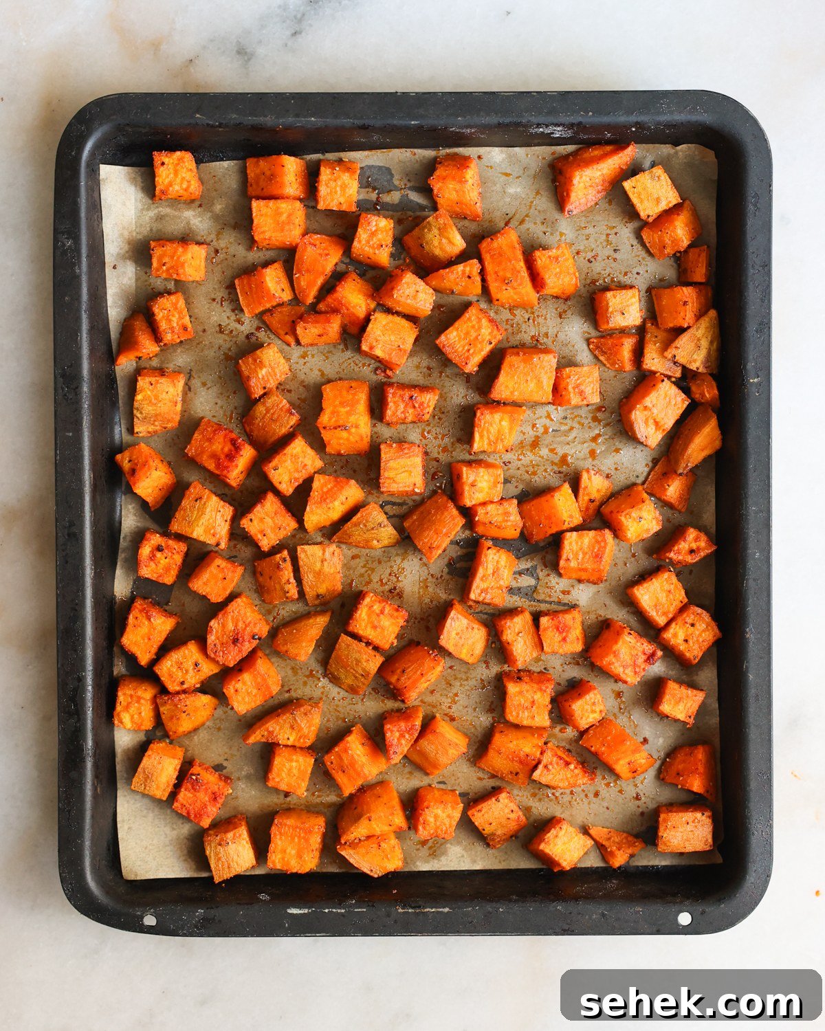 Perfectly Roasted Sweet Potatoes: Crispy Edges & Tender Centers 9 Roasted sweet potatoes on baking sheet.