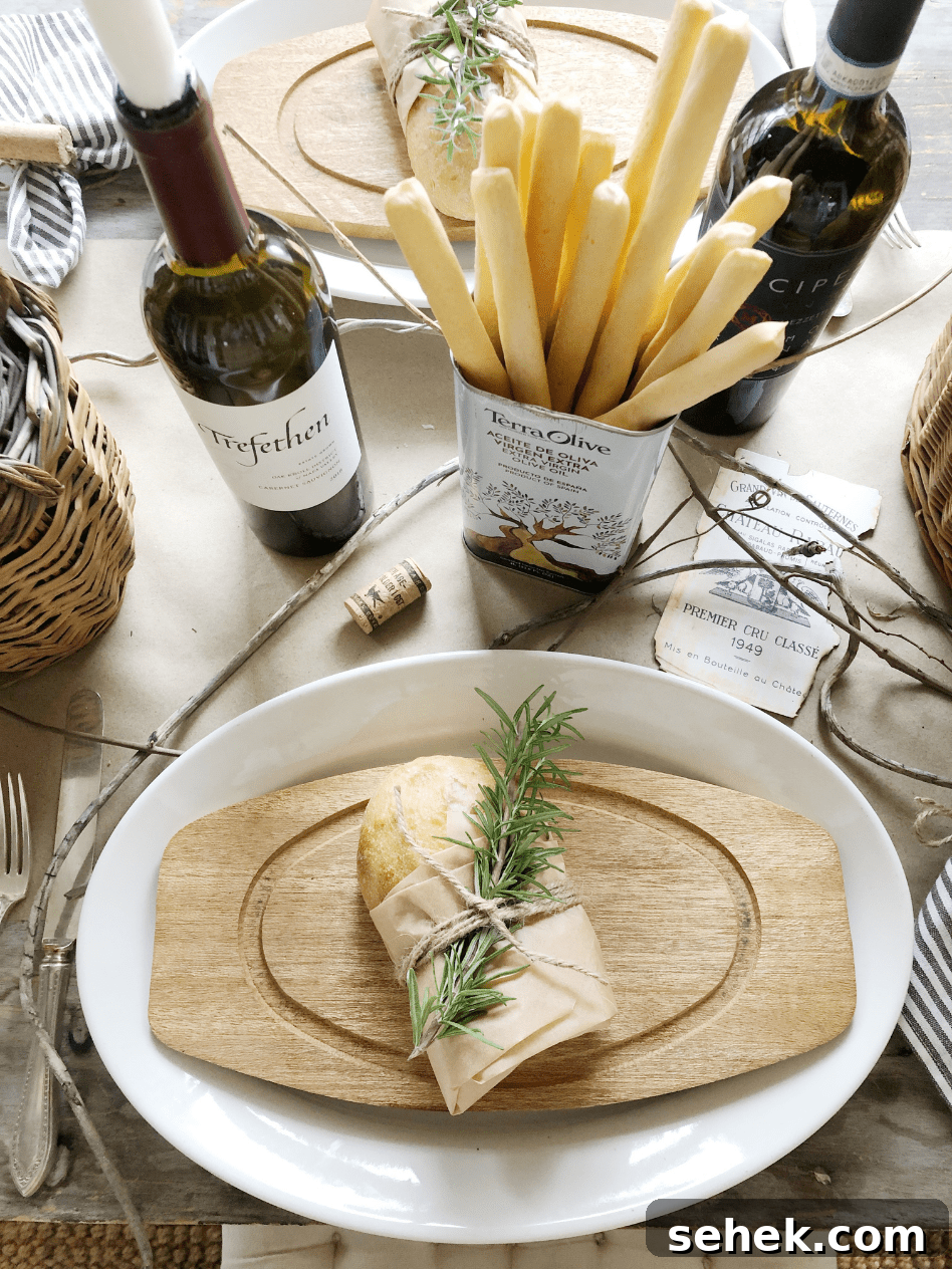 Italian-Inspired Tablescape Ideas for Elegant Dinner Parties 13 place setting with wood cutting board and roll wrapped in paper with rosemary