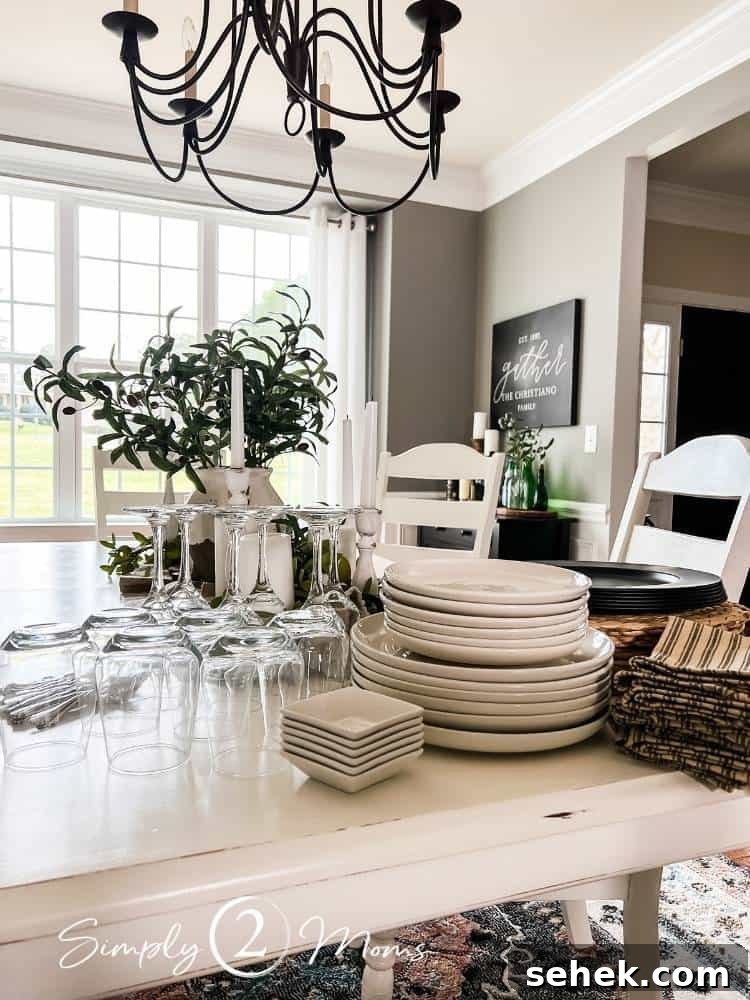Italian-Inspired Tablescape Ideas for Elegant Dinner Parties 2 table setting supplies stacked on dining room table including plates and glasses