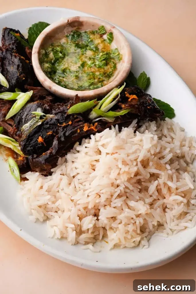 what to serve with coconut rice Coconut rice served alongside braised meat and herb sauce, showing how the rice pairs with savory main dishes.