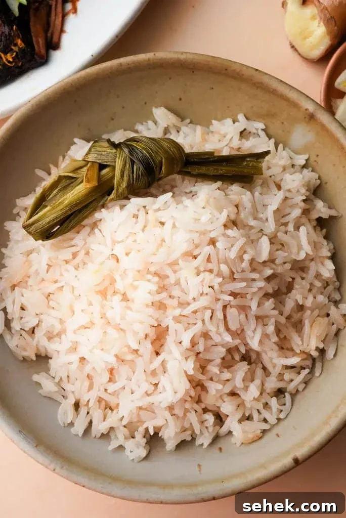 what to serve with coconut rice Coconut rice served alongside braised meat and herb sauce, showing how the rice pairs with savory main dishes.