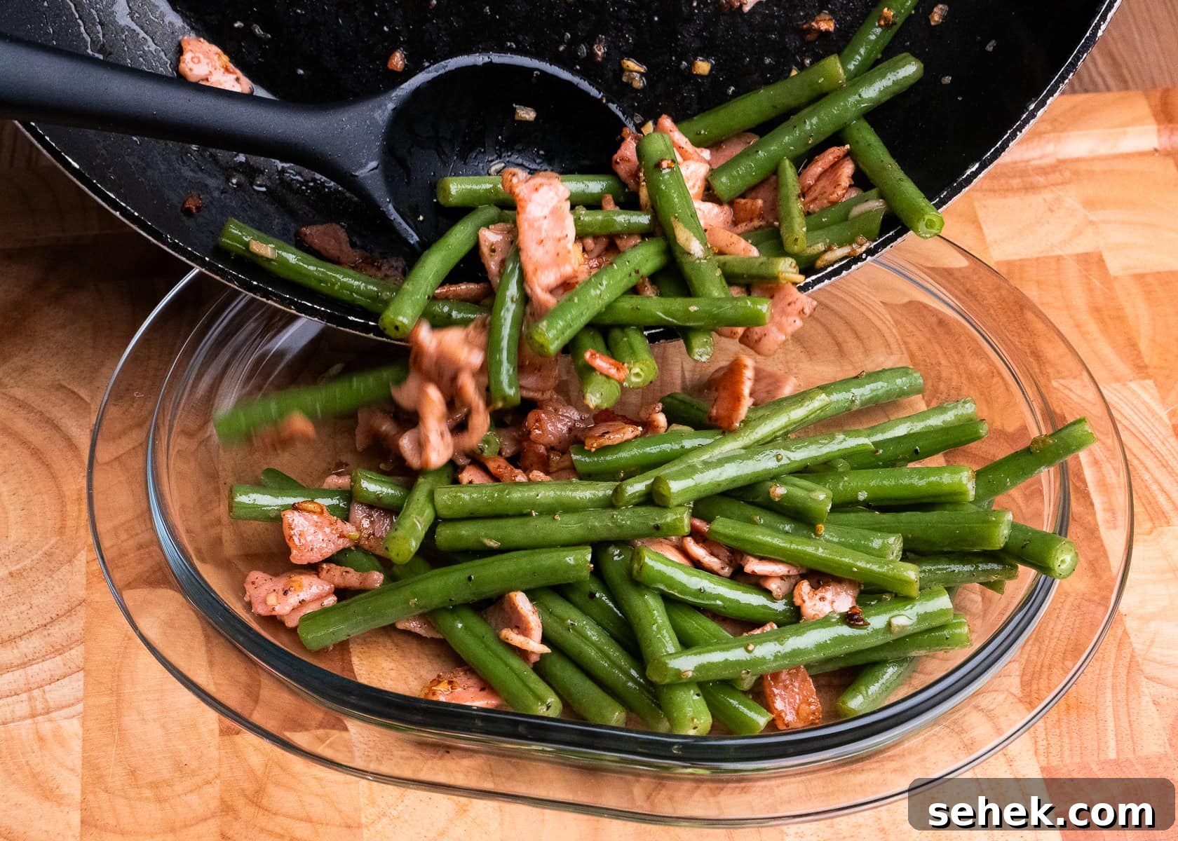 Garlic Green Beans with Crispy Bacon and Lemon Zest 3 Sauteed green beans and garlic and bacon being poured into a glass dish from a frying pan