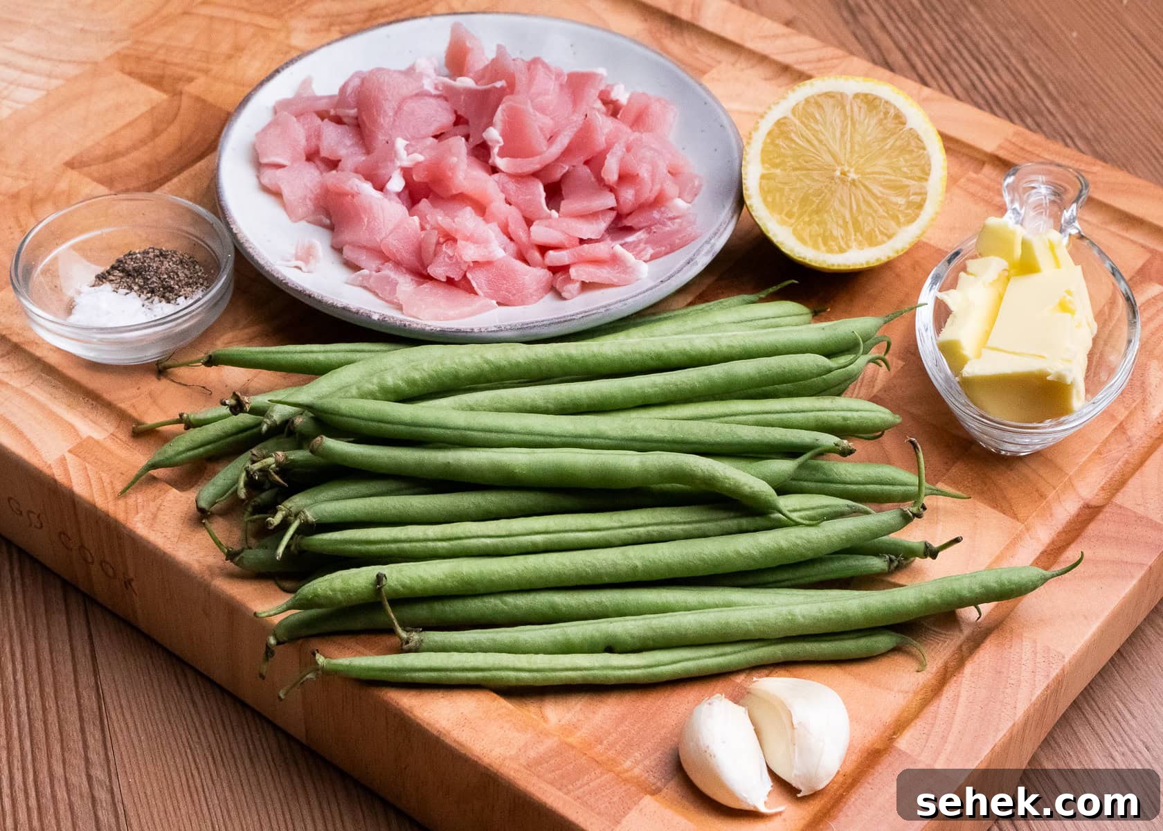 Garlic Green Beans with Crispy Bacon and Lemon Zest 16 Two garlic cloves, butter in a glass dish, salt , pepper , green beans, chopped up bacon and half a lemon a wooden board