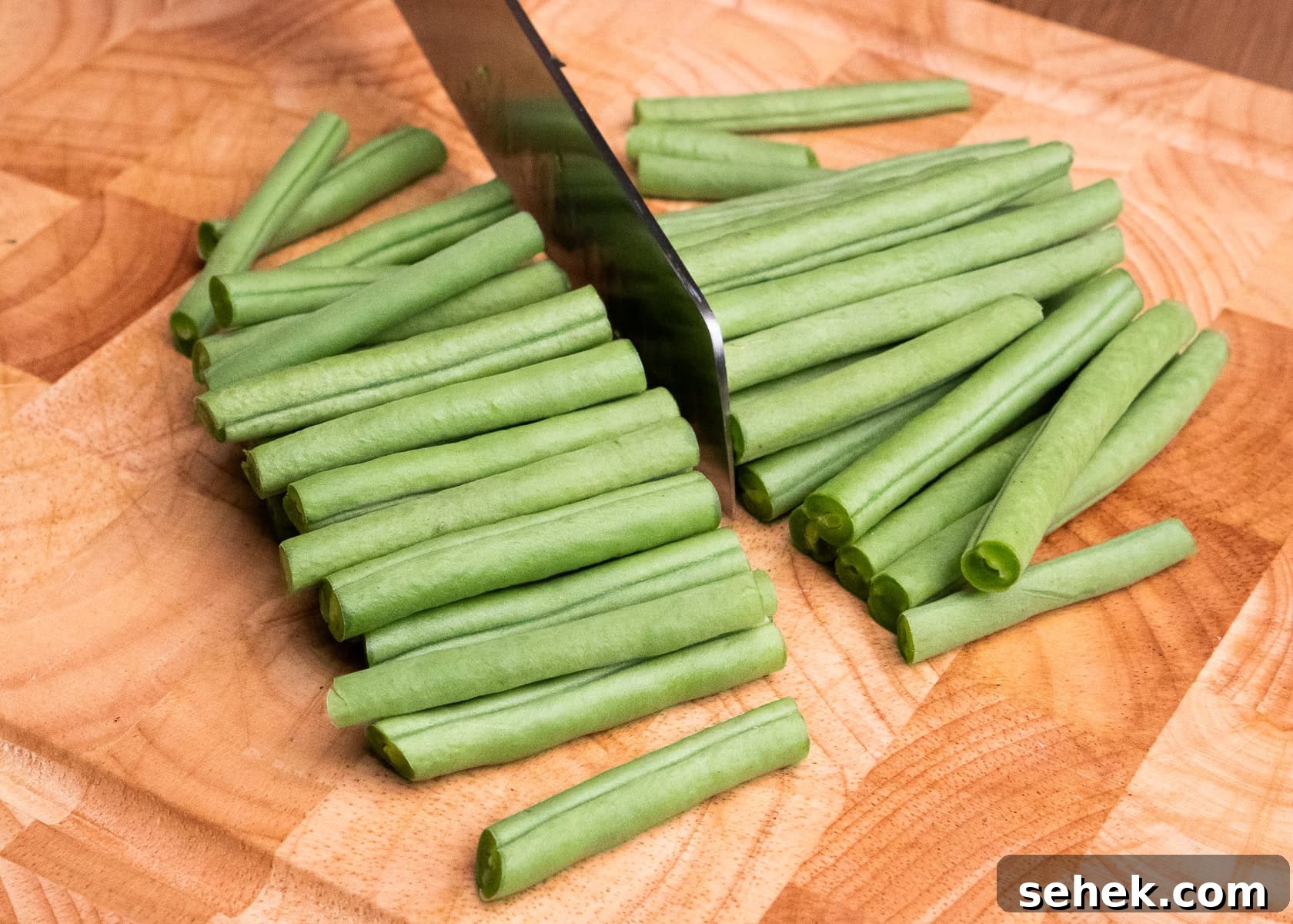 Garlic Green Beans with Crispy Bacon and Lemon Zest 23 Chopping the green beans in half with a sharp knife