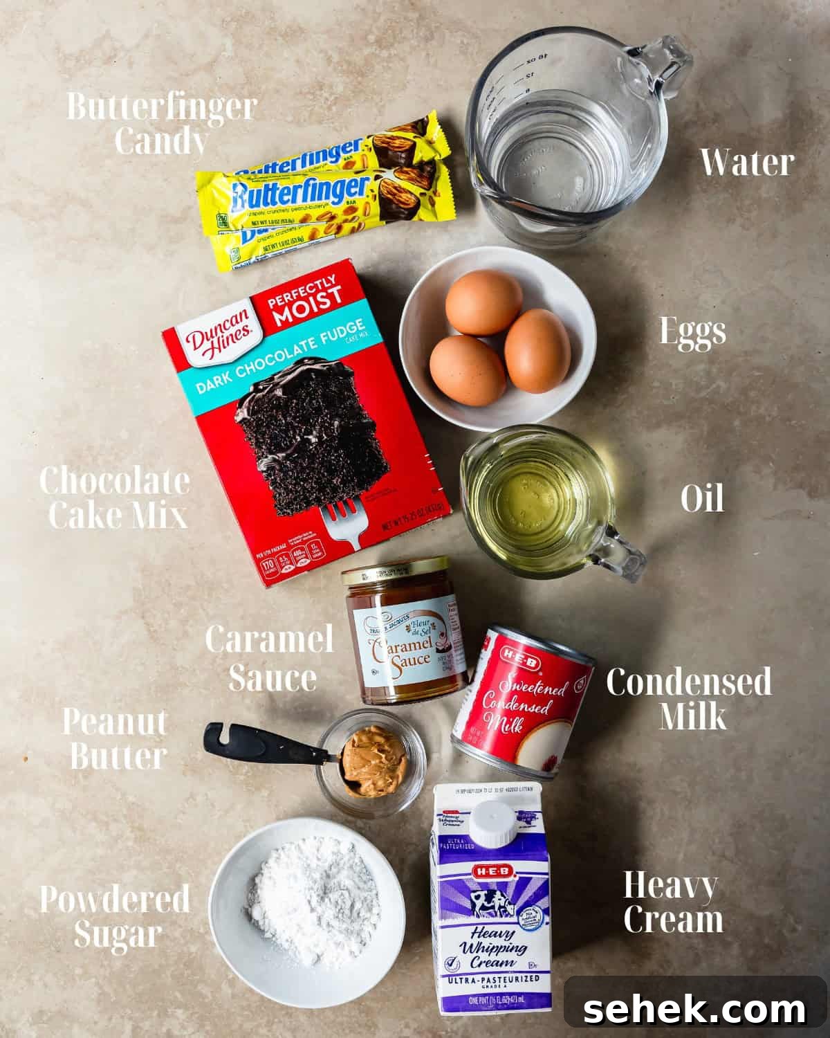 Gather all chocolate cake mix, eggs, water and oil for the cake, sweetened condensed milk, caramel sauce, heavy cream, powdered sugar and butterfinger candy. 