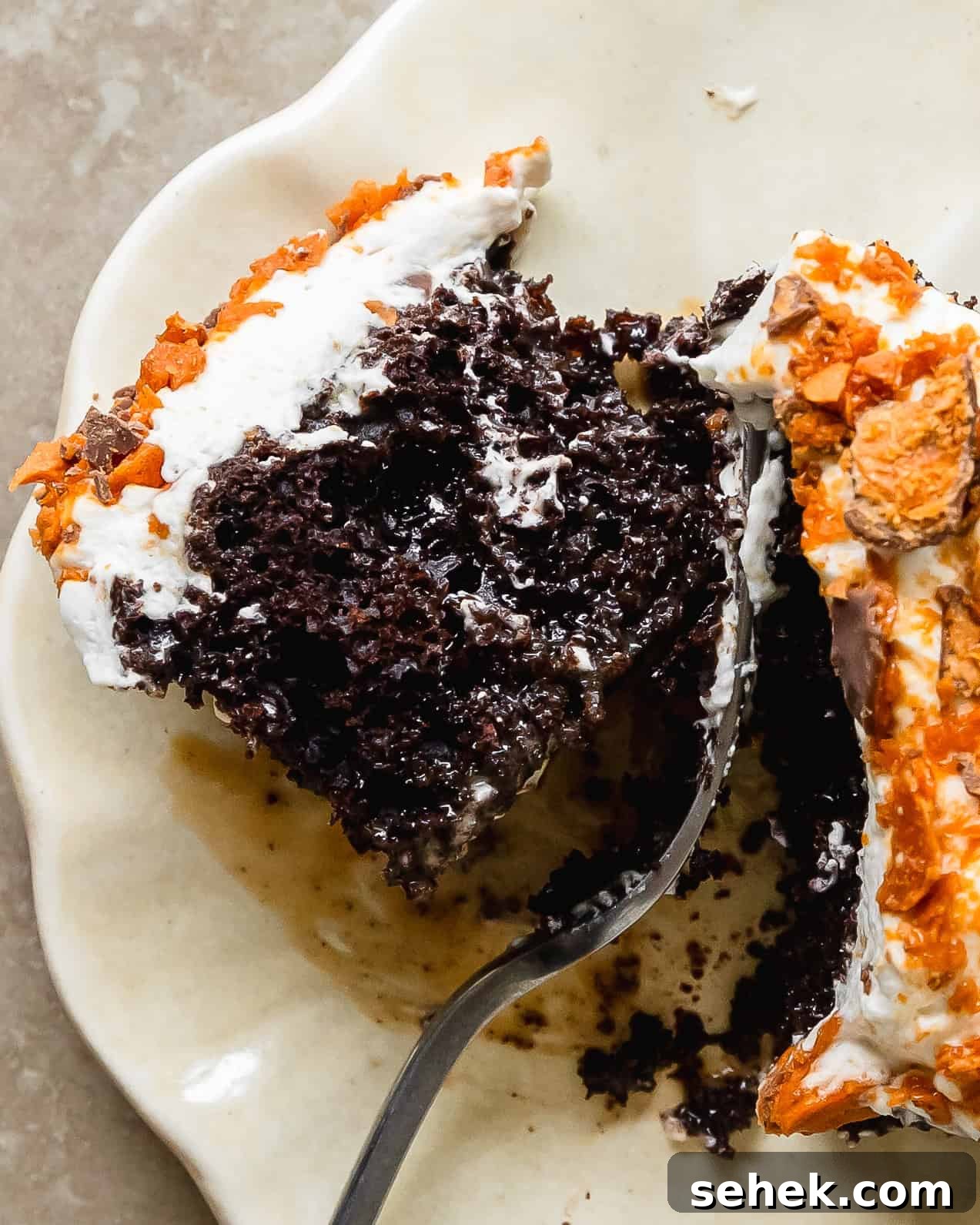 Butterfinger cake is a decadent poke cake made from moist chocolate or yellow cake, filled with gooey caramel sauce, topped with whipped topping and crushed butterfinger candy. This butterfinger candy bar cake comes together quickly and easily, making this the perfect dessert for potlucks, gatherings and celebrations. 