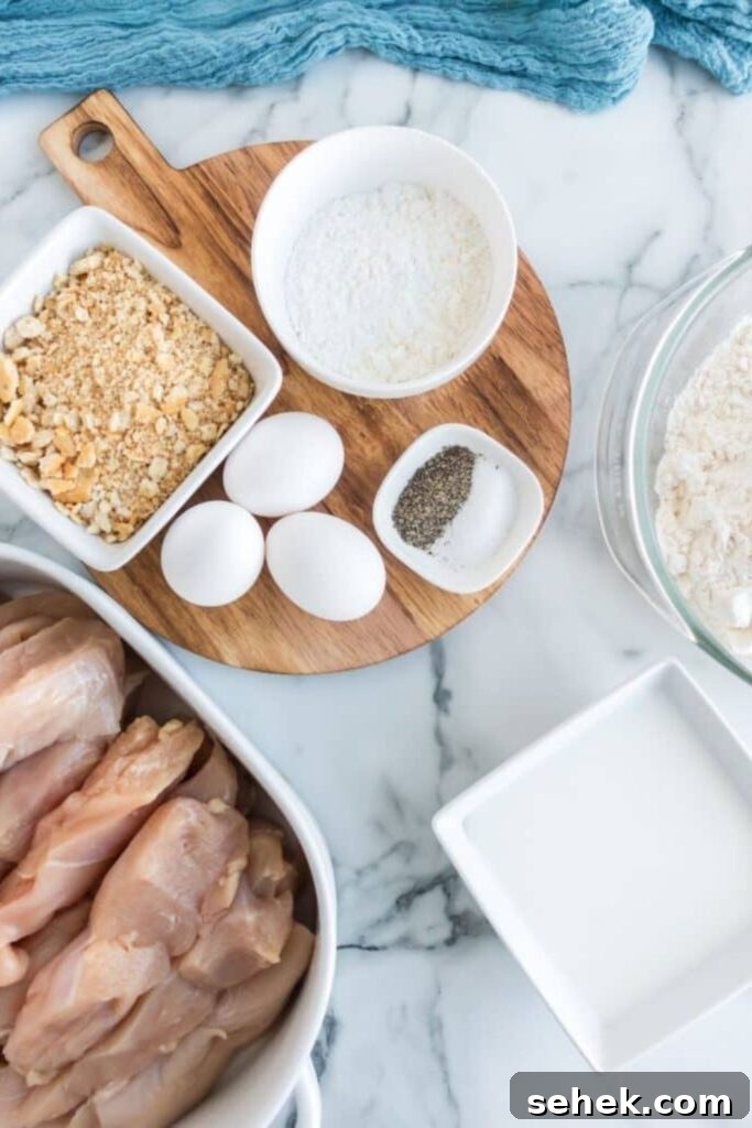 Crispy Homemade Chicken Strips: Oven-Baked & Buttermilk-Marinated 3 ingredients for homemade chicken strips on table in single serve bowls to show each ingredient