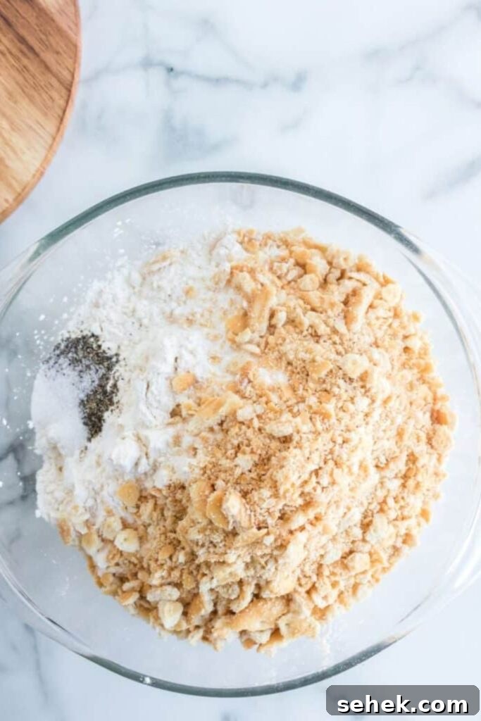 Crispy Homemade Chicken Strips: Oven-Baked & Buttermilk-Marinated 4 crushed crackers, spices and flour in a small bowl on table