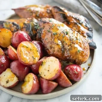 Instant Pot Honey Mustard Chicken with Roasted Potatoes 14 Seared honey mustard chicken and halved red potatoes on a grey plate on a marble surface