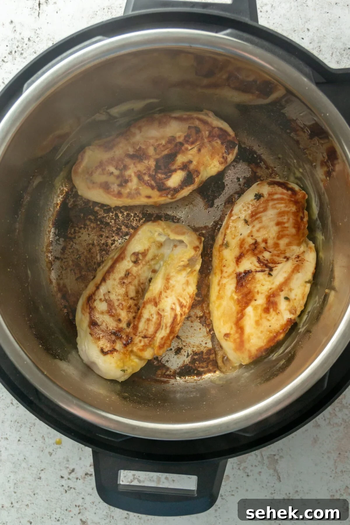 Instant Pot Honey Mustard Chicken with Roasted Potatoes 5 Golden chicken breasts cooking in an Instant Pot