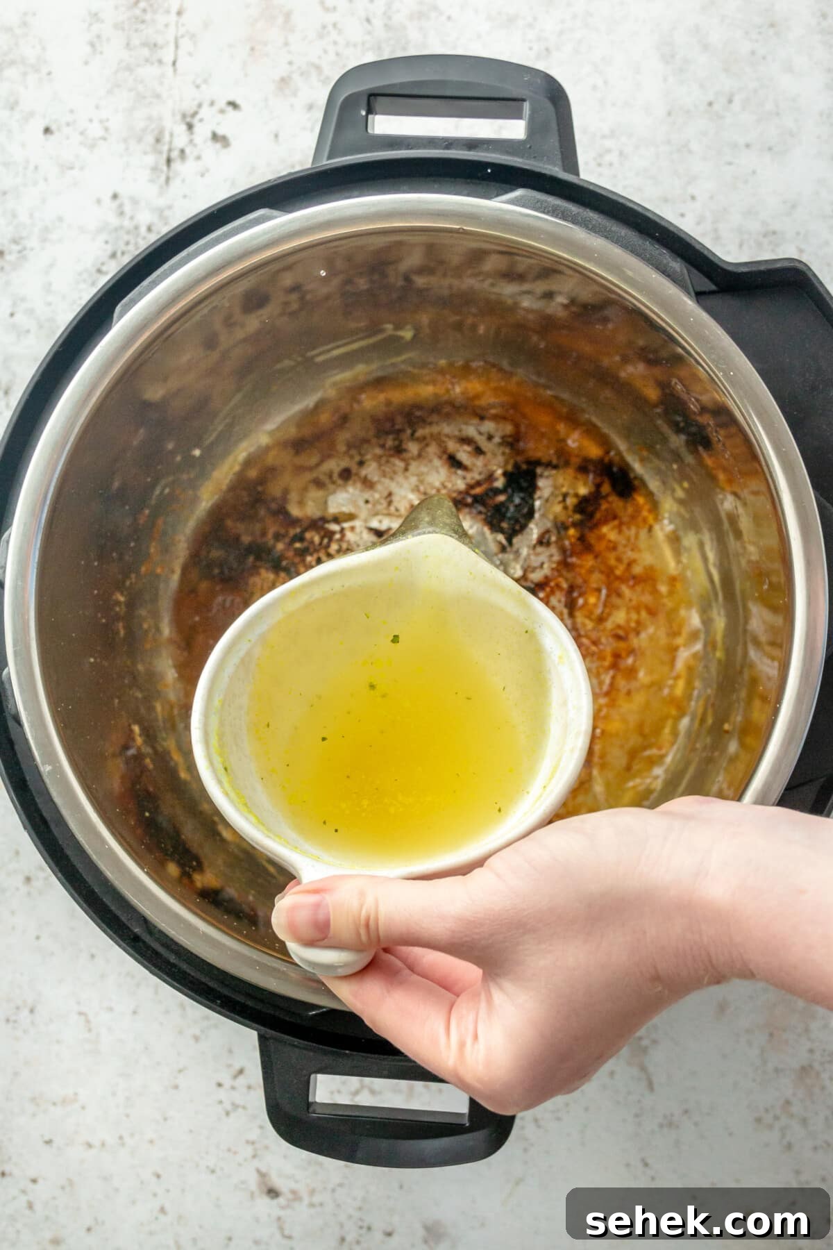 Instant Pot Honey Mustard Chicken with Roasted Potatoes 6 Chicken broth being poured into an Instant Pot