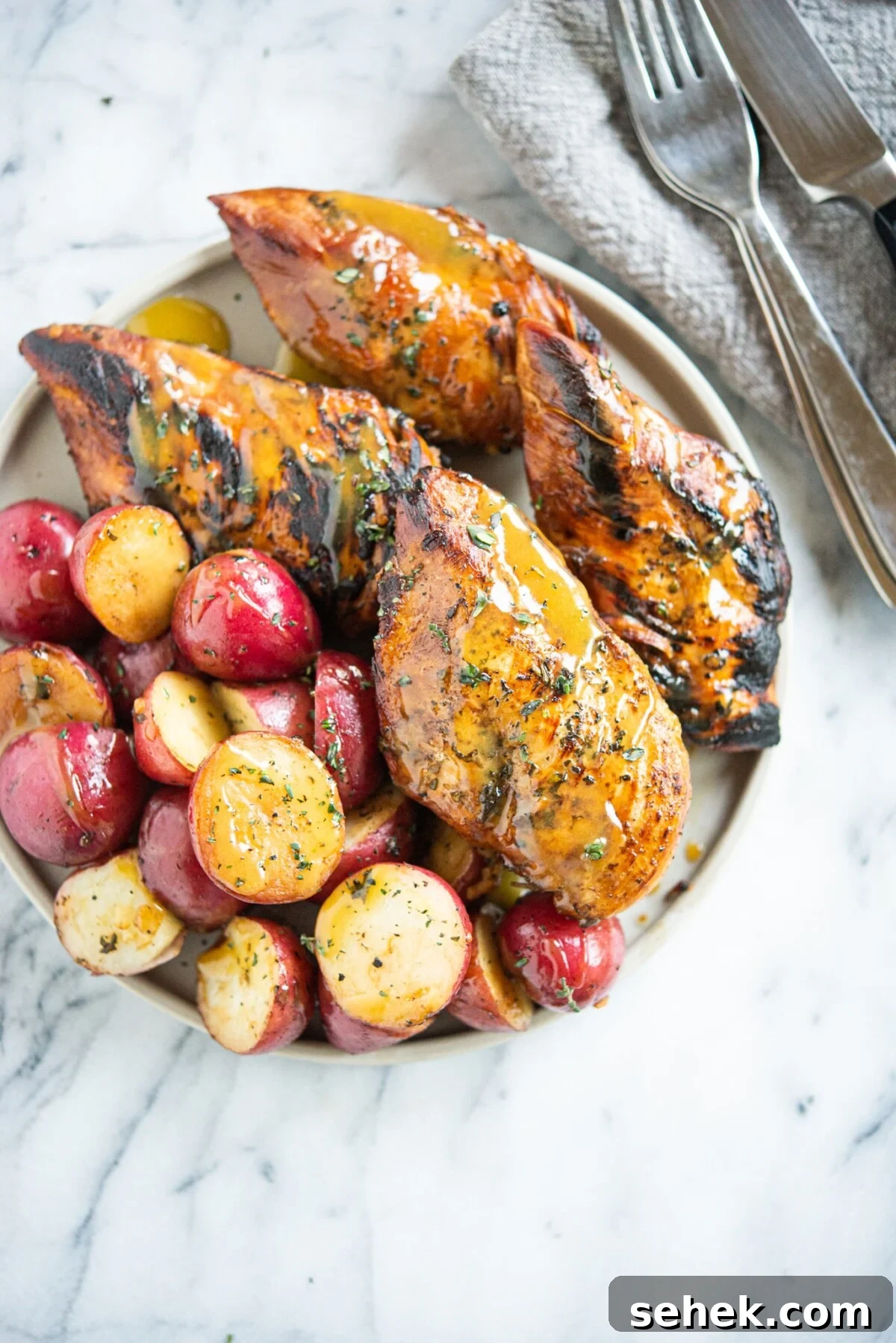 Instant Pot Honey Mustard Chicken with Roasted Potatoes 8 Seared honey mustard chicken and halved red potatoes on a grey plate