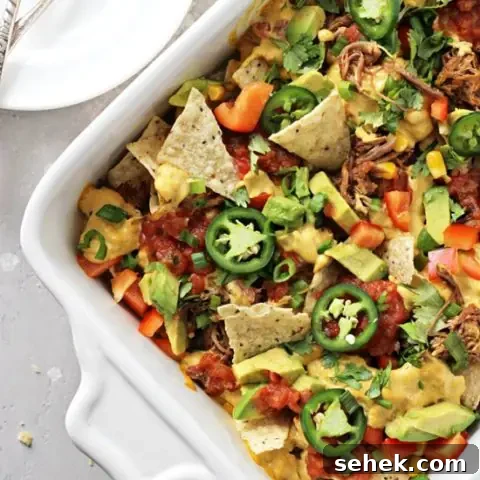 Dairy-Free Nachos Recipe: Crispy, Cheesy Vegan Nachos 7 A white baking dish filled with Dairy Free Nachos.