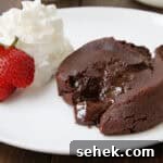 Ultimate Chocolate Lava Cake Recipe: Gooey Molten Center in 20 Minutes 2 Chocolate Molten Lava Cake with spoon, strawberry, and whipped cream on plate