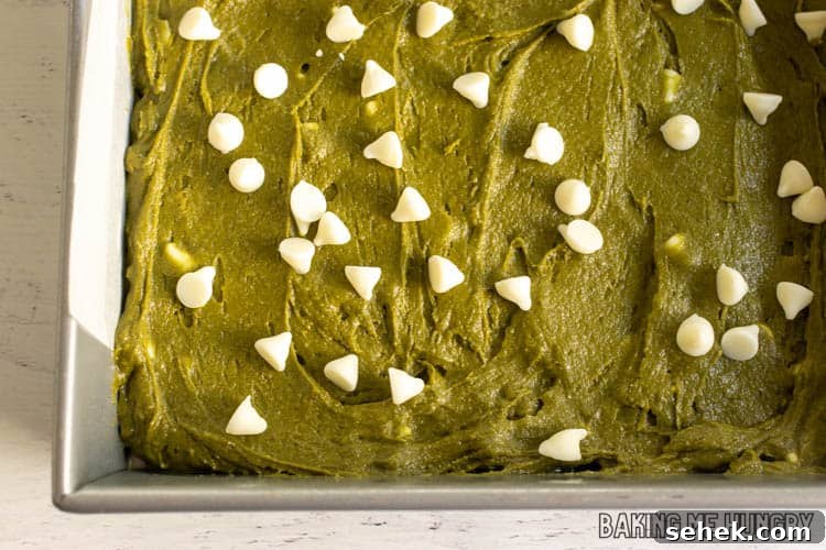 Chewy Matcha Blondies with White Chocolate Swirls 9 batter in pan with white chocolate chips on top