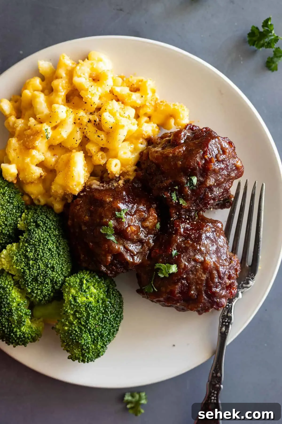 Sticky BBQ Meatballs Recipe That Melts in Your Mouth 2 overhead: BBQ meatballs on a cream plate with mac and cheese and steamed broccoli