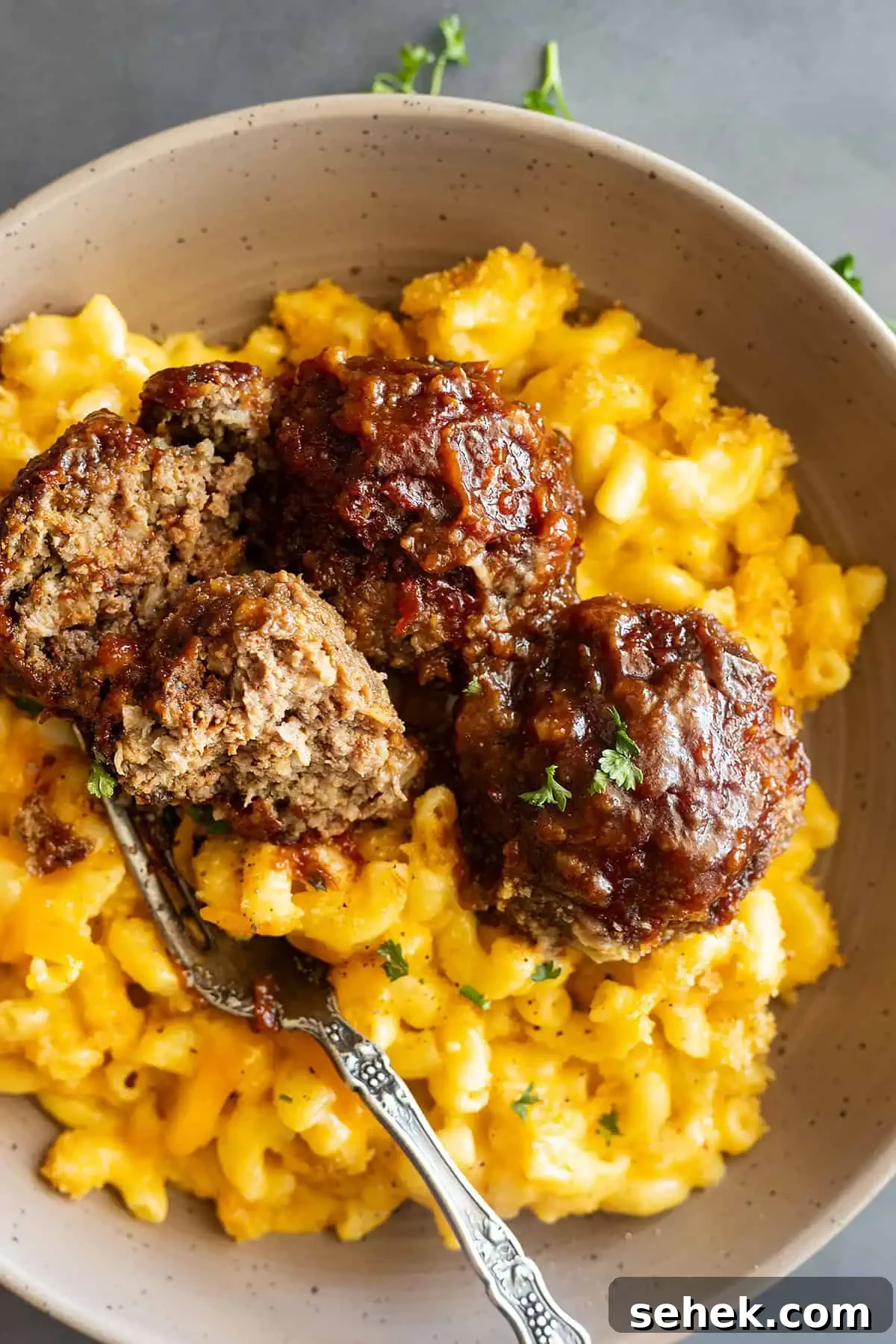 Sticky BBQ Meatballs Recipe That Melts in Your Mouth 6 overhead: BBQ meatballs in oven over mac and cheese in a bowl