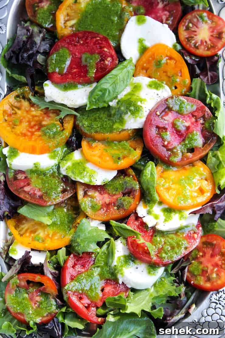 Caprese Salad with Fresh Basil Vinaigrette 2 Insalata caprese with fresh mozzarella and basil dressing on serving platter.