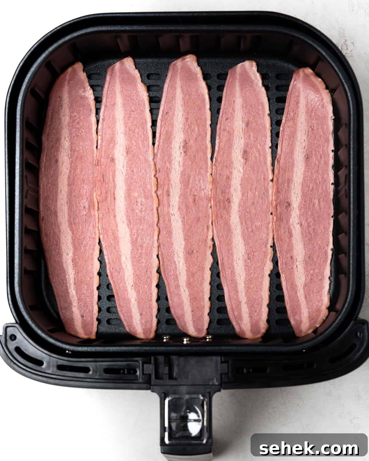 Crispy Air Fryer Turkey Bacon Recipe for Perfect Breakfast 3 single layer of uncooked turkey bacon in the air fryer