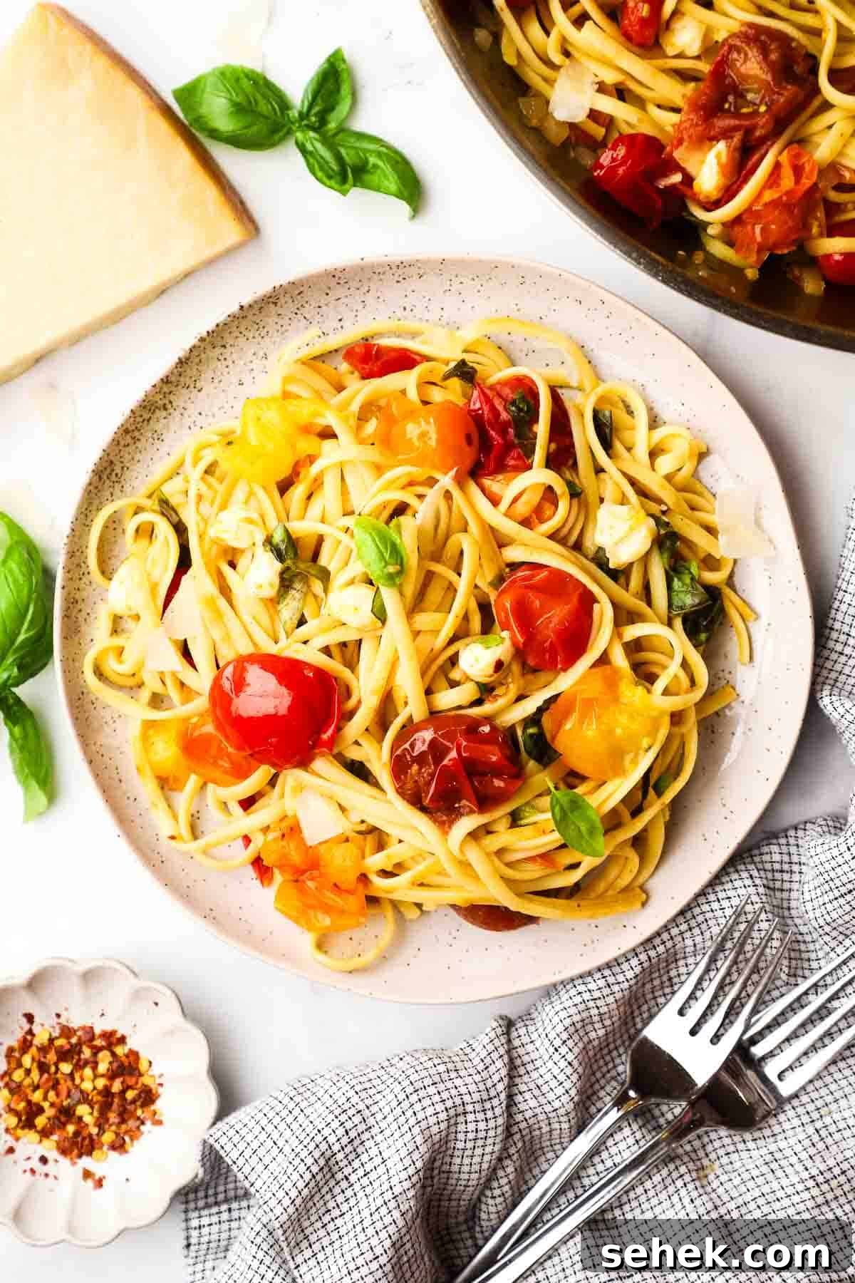 Quick Cherry Tomato Pasta with Garlic and Basil 2 overhead view of a plate of pasta with cherry tomatoes, cheese, and basil