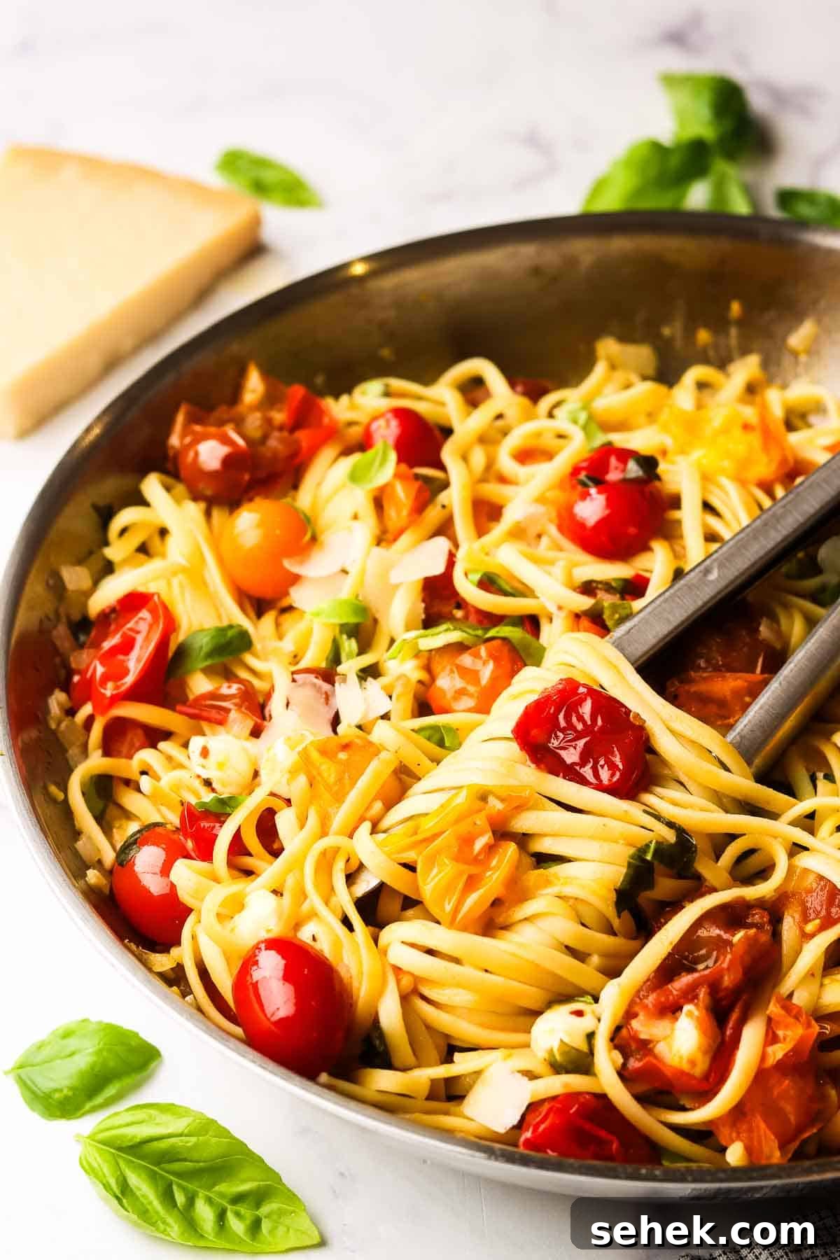 Quick Cherry Tomato Pasta with Garlic and Basil 14 a skillet of cherry tomato pasta with tongs