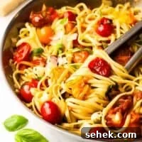Quick Cherry Tomato Pasta with Garlic and Basil 15 A pan of cherry tomato pasta with tongs.