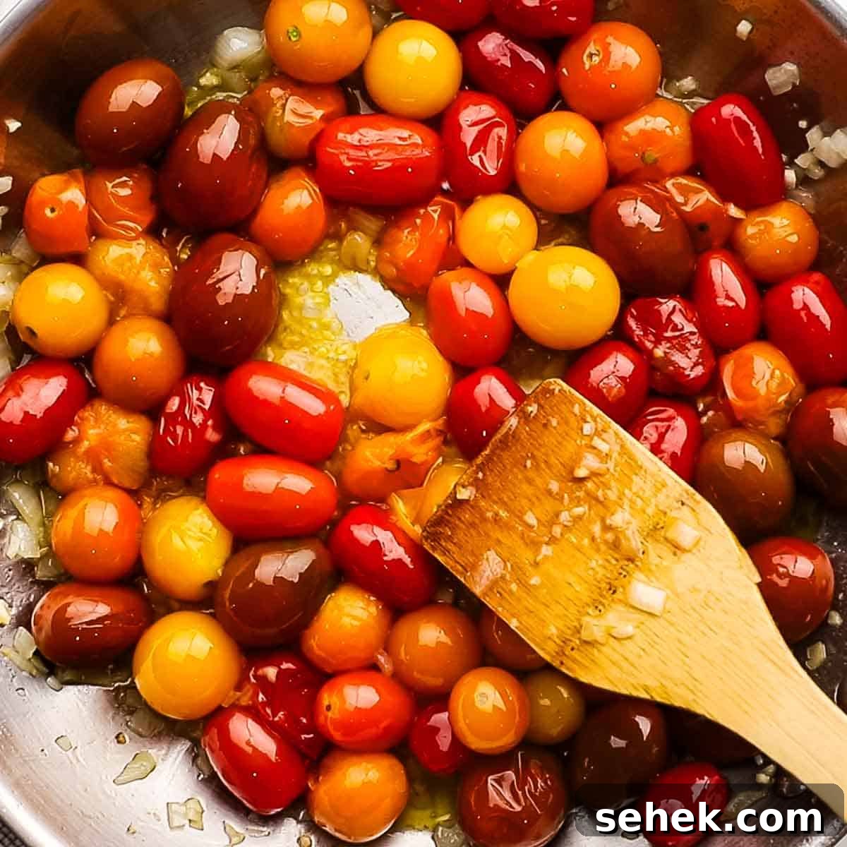 Quick Cherry Tomato Pasta with Garlic and Basil 8 smashing cherry tomatoes in the skillet with a wooden spoon