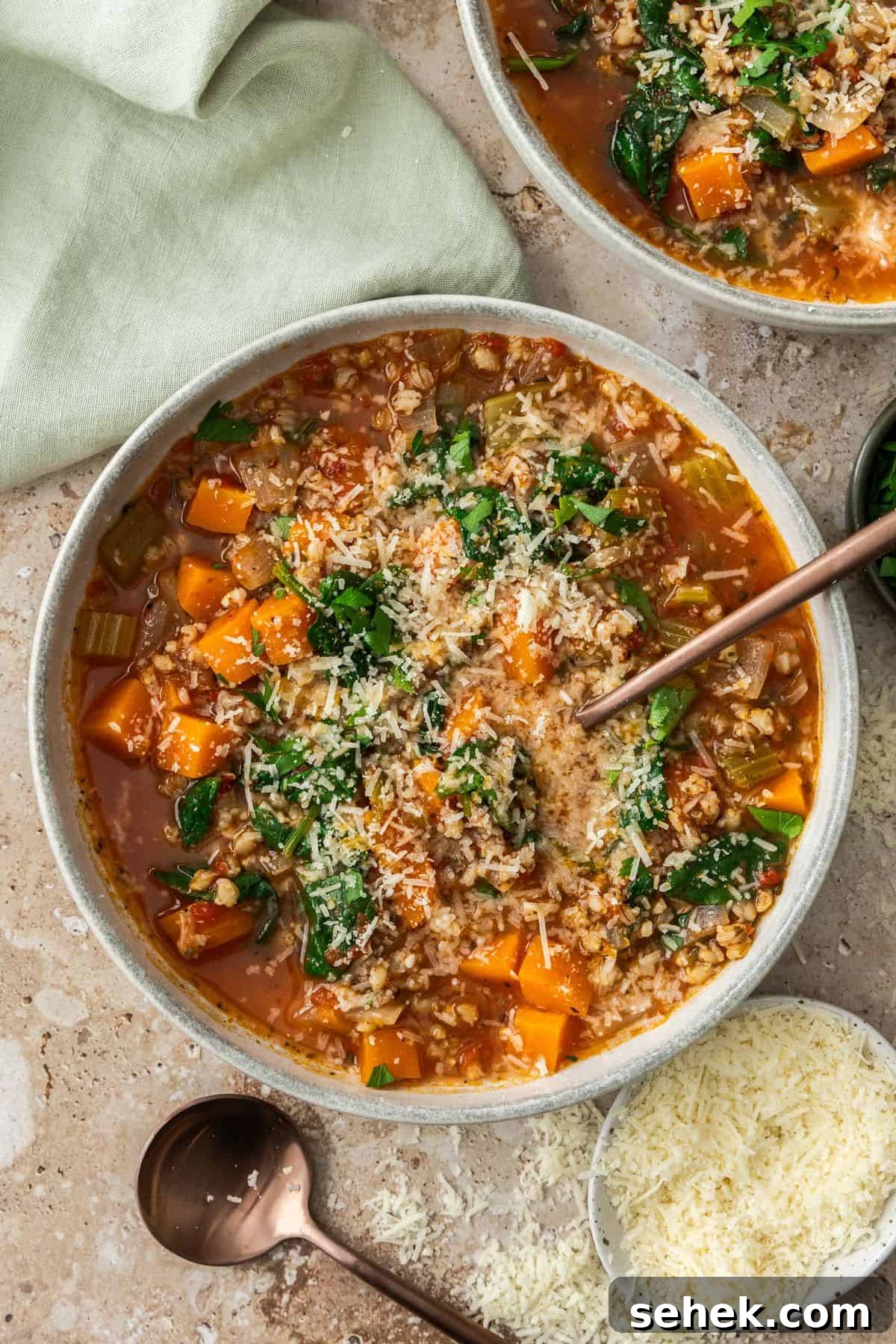 Mediterranean Barley Vegetable Soup Recipe for Flavorful Comfort 2 Two bowls with serves of Creamy Chicken and Barley Soup, one with a spoon in it.