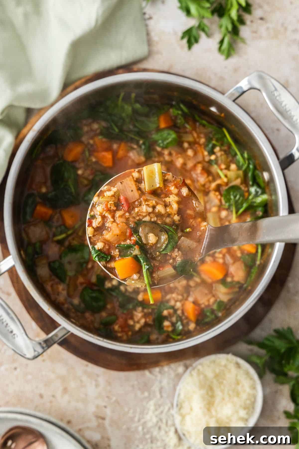 Mediterranean Barley Vegetable Soup Recipe for Flavorful Comfort 7 A soup ladle holding up some Mediterranean Vegetable and Barley Soup, ready to put into a bowl.