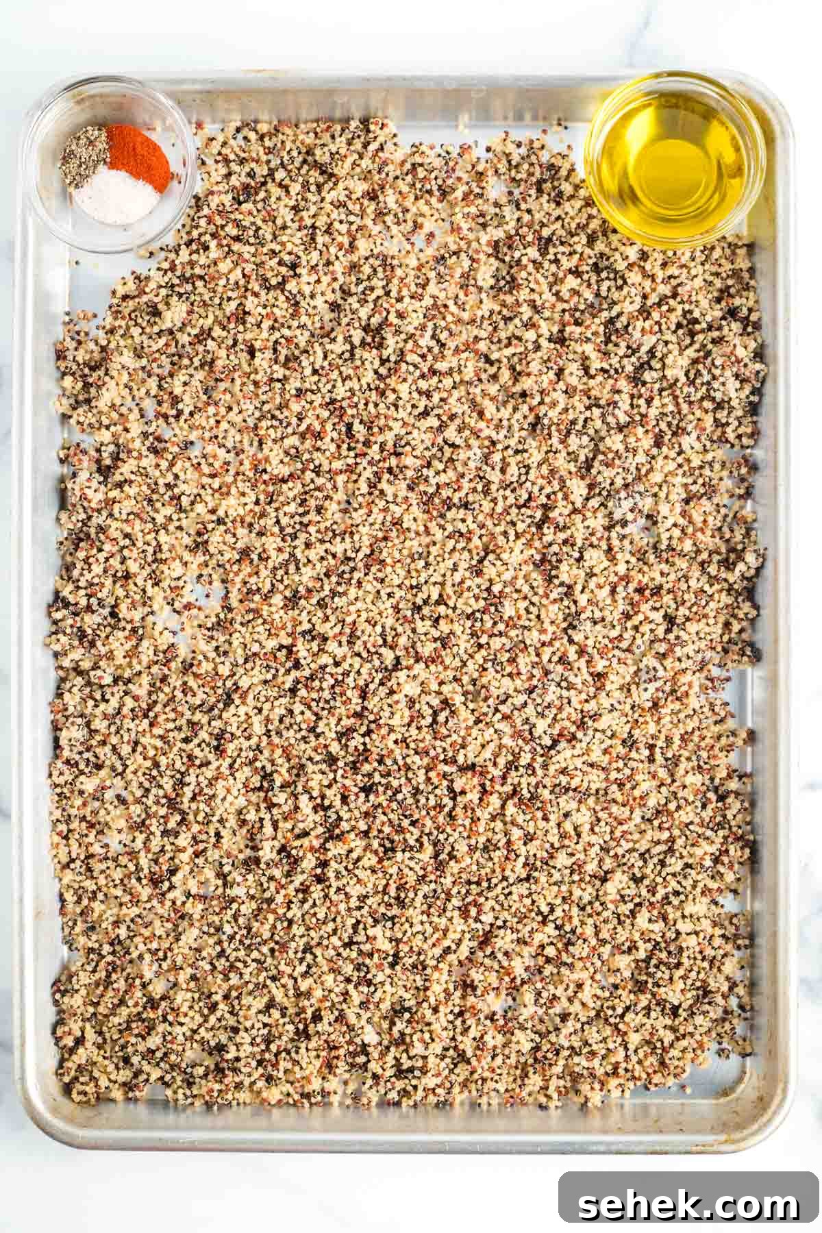 Shaved Fennel & Arugula Salad with Crispy Quinoa Crunch 4 Large rimmed baking sheet with cooked quinoa spread out, a small dish of olive oil and one with paprika, salt and pepper.