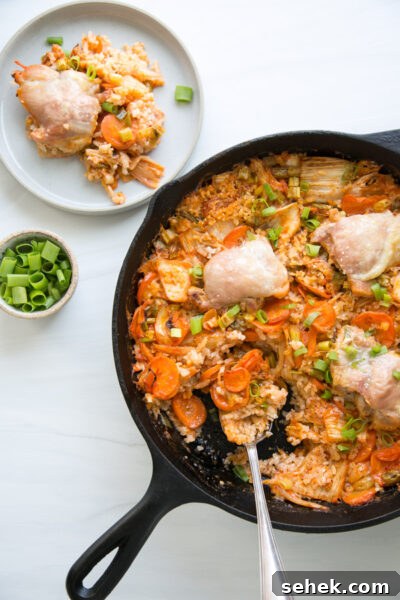 5-Ingredient Gluten-Free Kimchi Chicken Casserole 13 finished kimchi chicken casserole in a skillet with a spoon