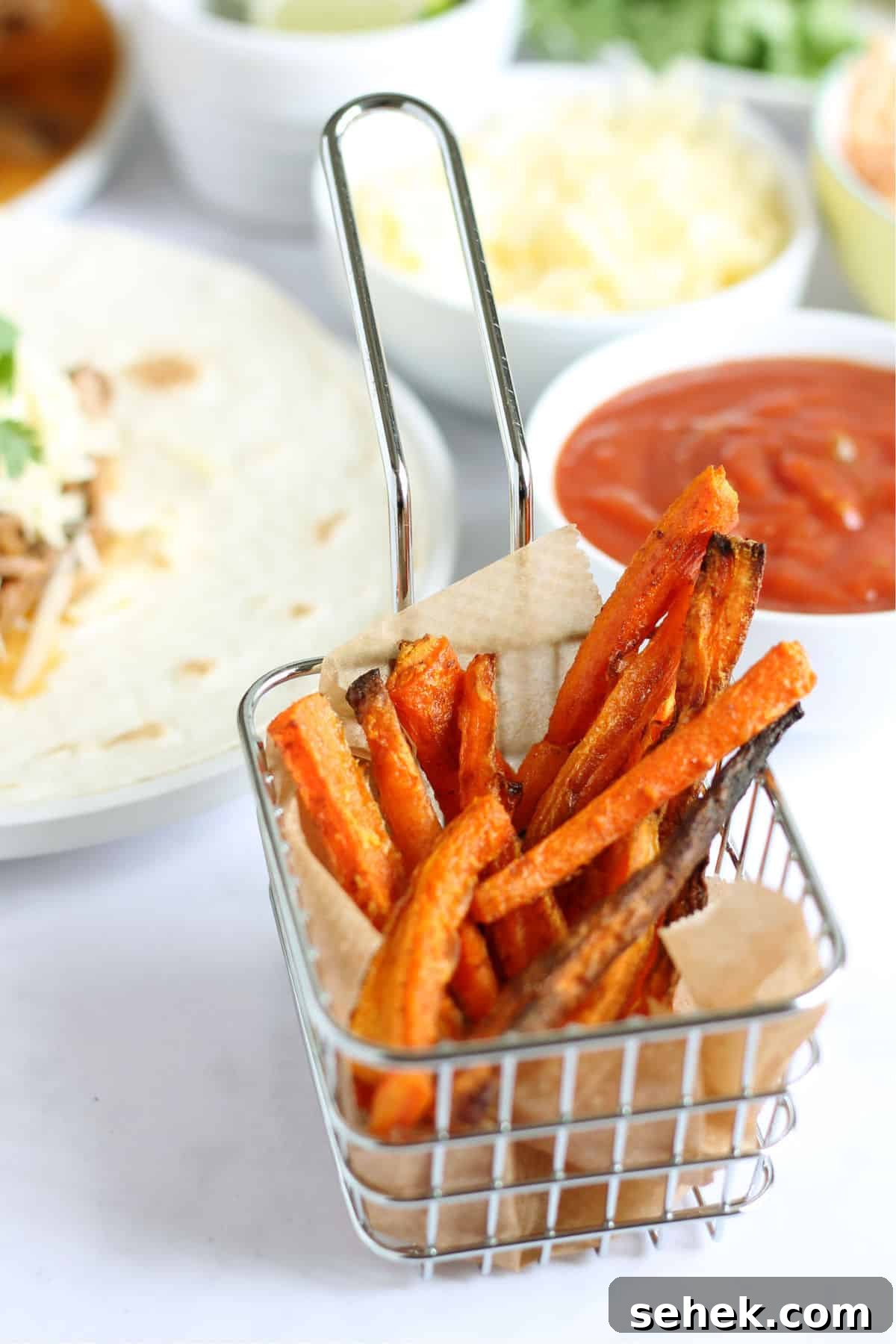 A portion of baked carrot fries with homemade ketchup