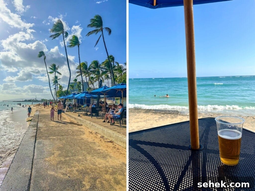 Waikīkī Beach Bar Cocktails with Ocean Views 5 Koa Oasis Booze Shack outdoor seating area by the beach with blue umbrellas and palm trees in the background.